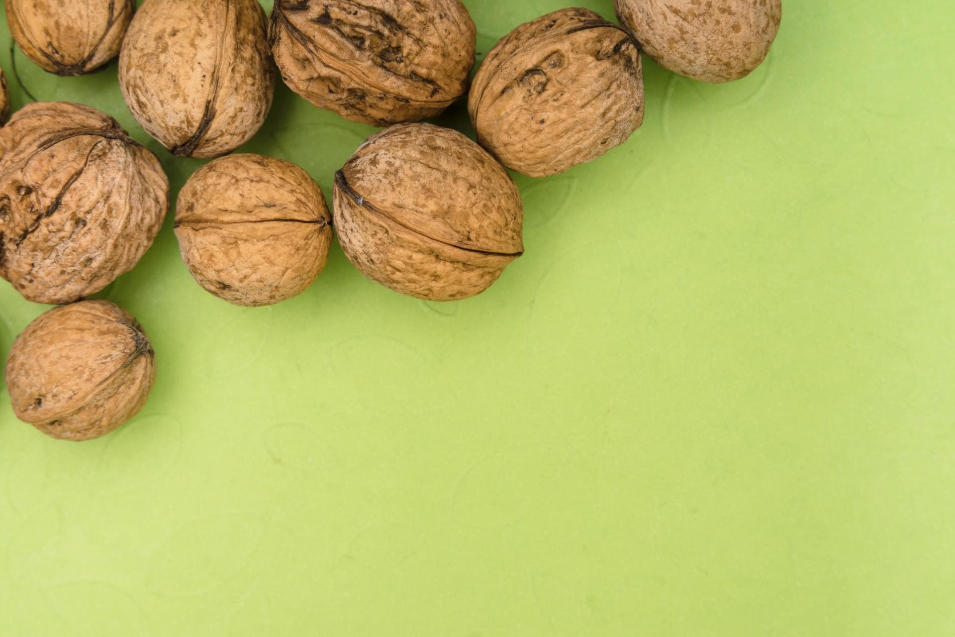 Walnuts on a green background illustrating prostate size comparison