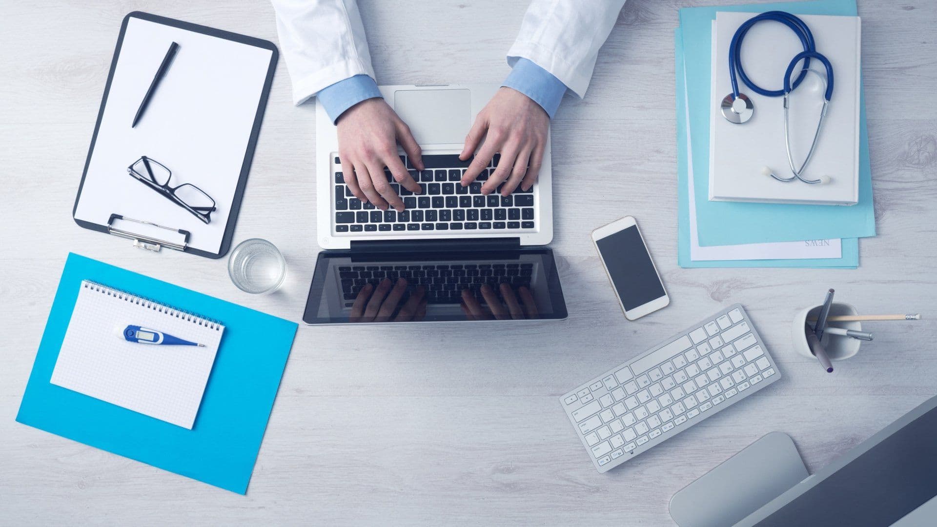 Physician workspace with laptop, stethoscope, and desk tools